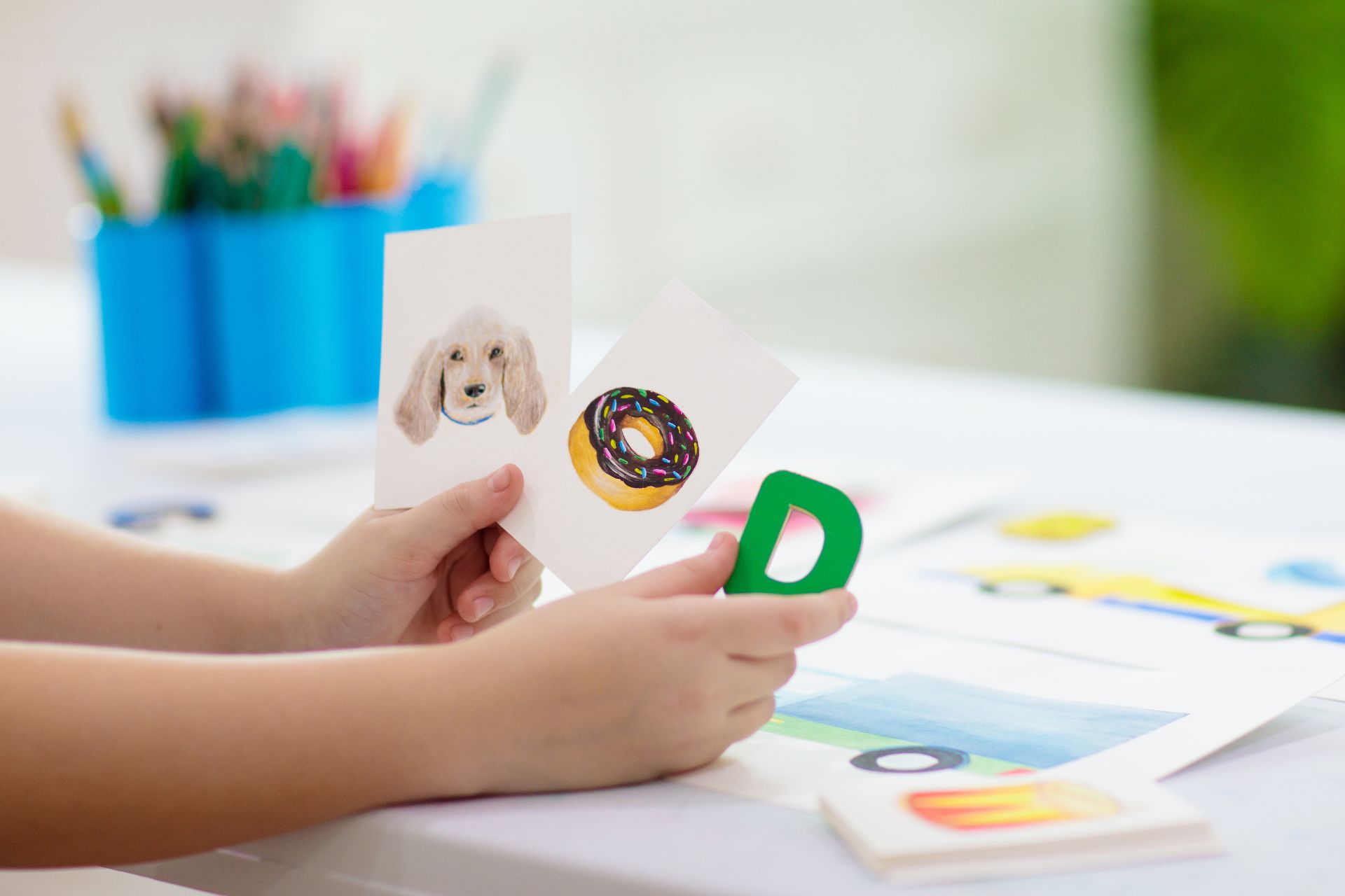 Child learning the letter and sound of letter D having also a pictures of dog and donut